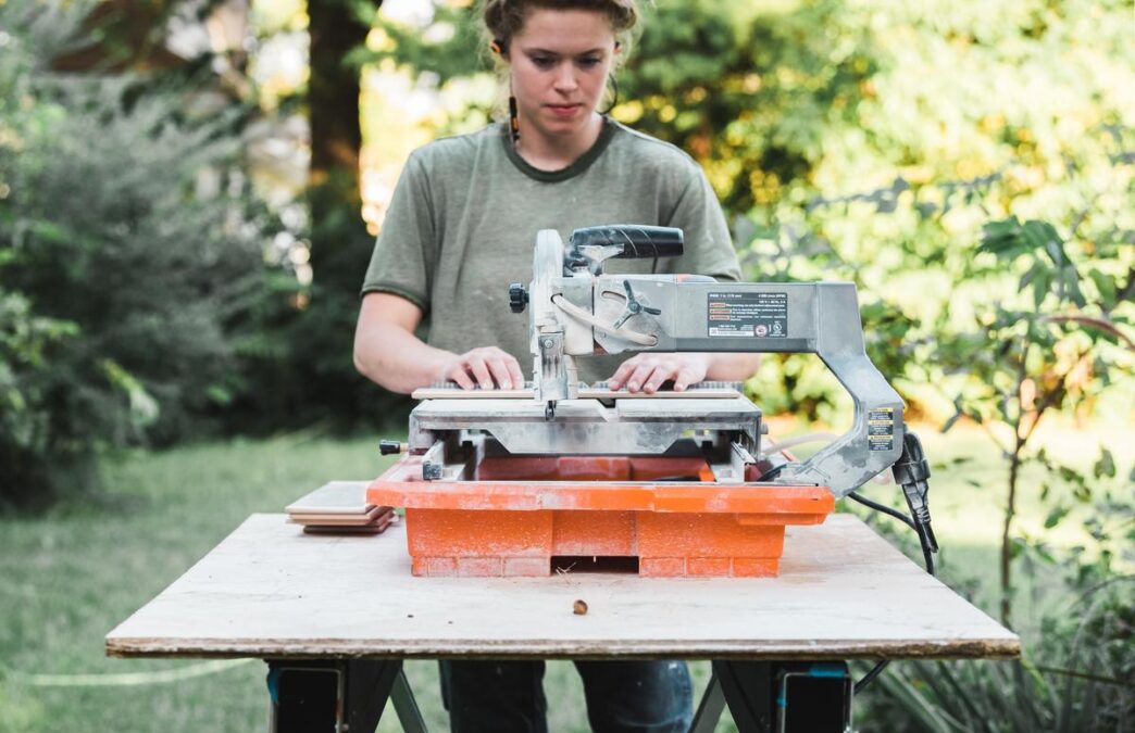 A polished table saw in a sunlit workshop surrounded by woodworking tools and materials.