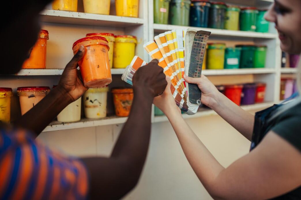 A vibrant DIY workspace with paint cans, tools, and a partially finished chair.